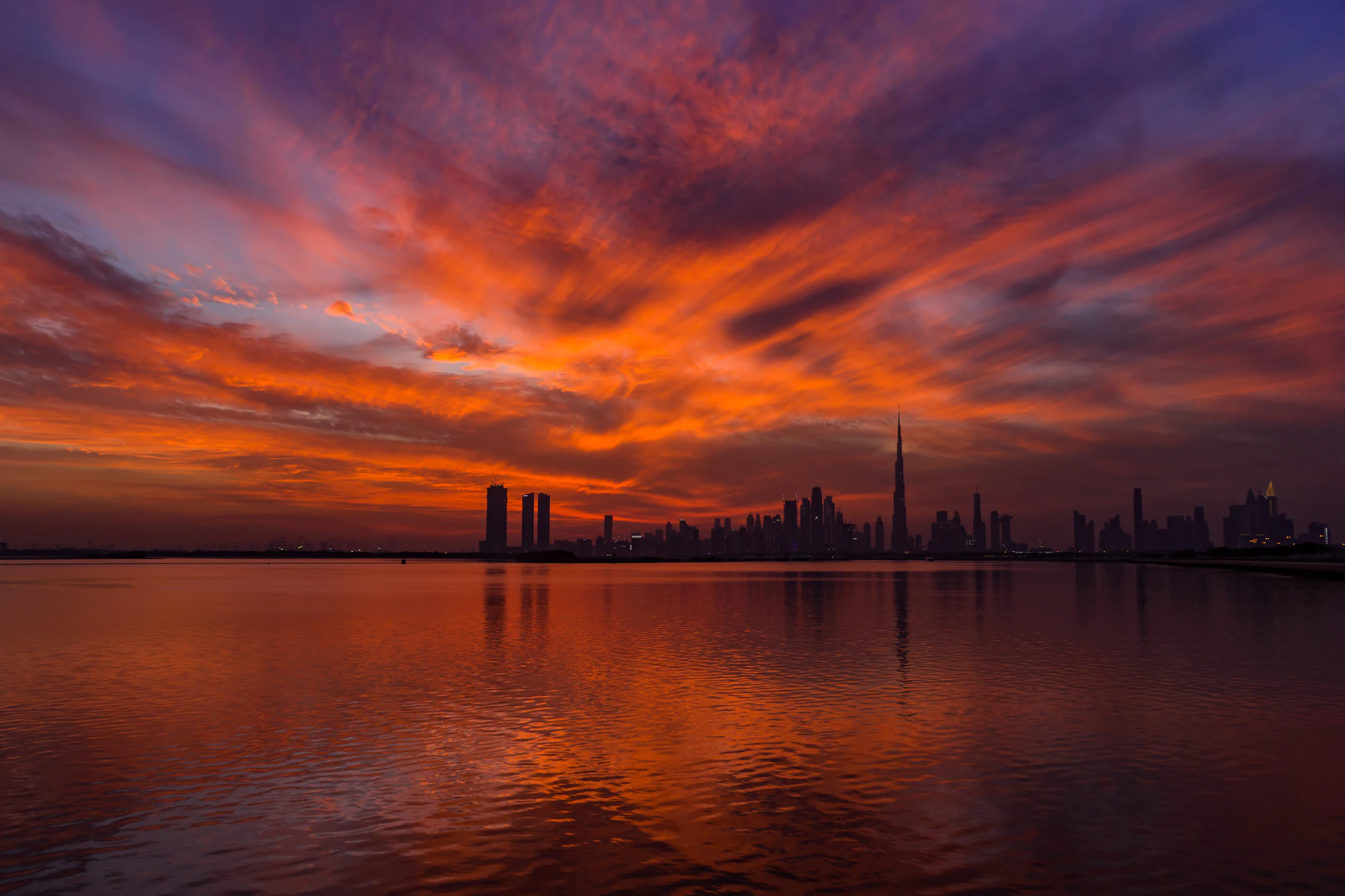 The sun setting behind a city skyline